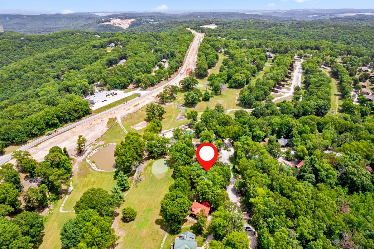 A landscape-style shot featuring expansive green spaces, scattered homes, and a winding road. The open surroundings communicate a sense of serene distance while suggesting quick, easy access to area attractions.