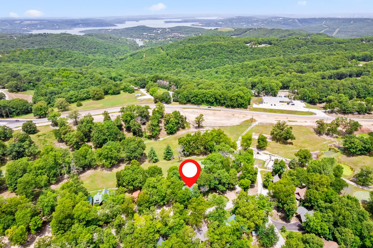 A serene lakeside landscape with lush greenery, a scenic view of the lake, and sprawling landscapes ideal for hiking and exploring. The tranquil atmosphere suggests opportunities for both human and canine guests to enjoy nature trails and lakeside strolls.